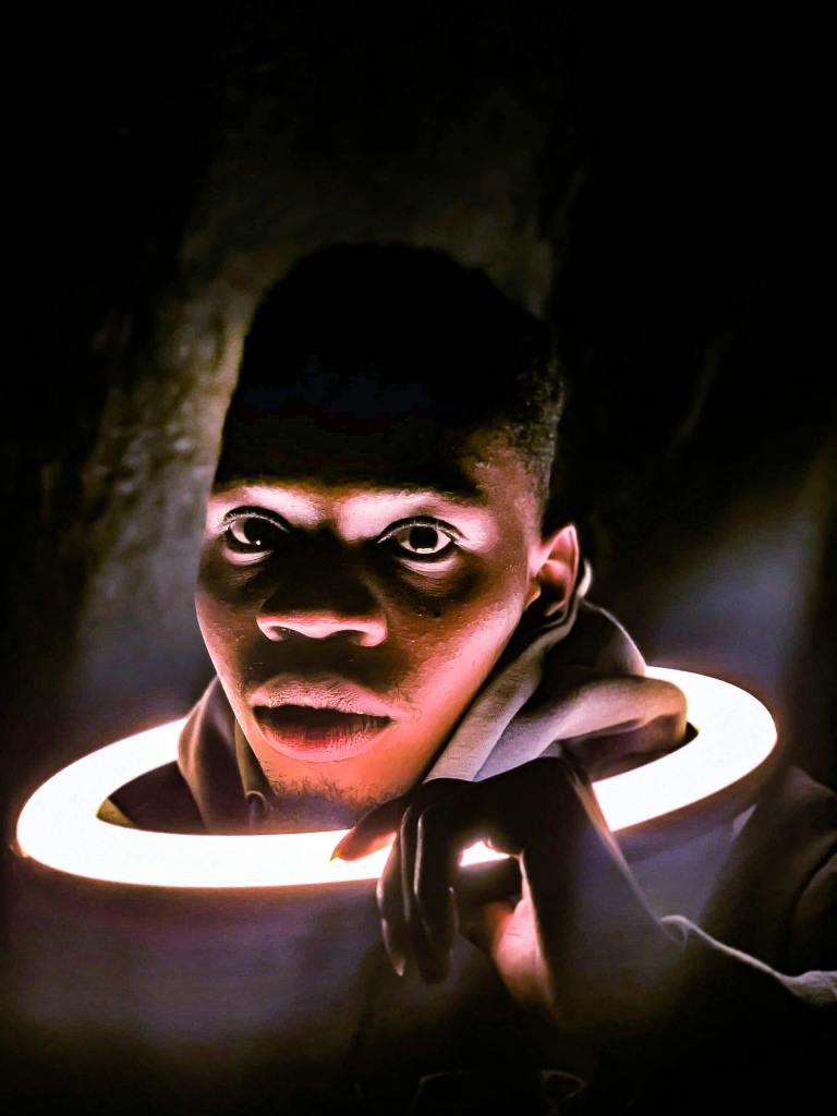 A black man with a ring light around his head, which causes some weird lighting things to happen.